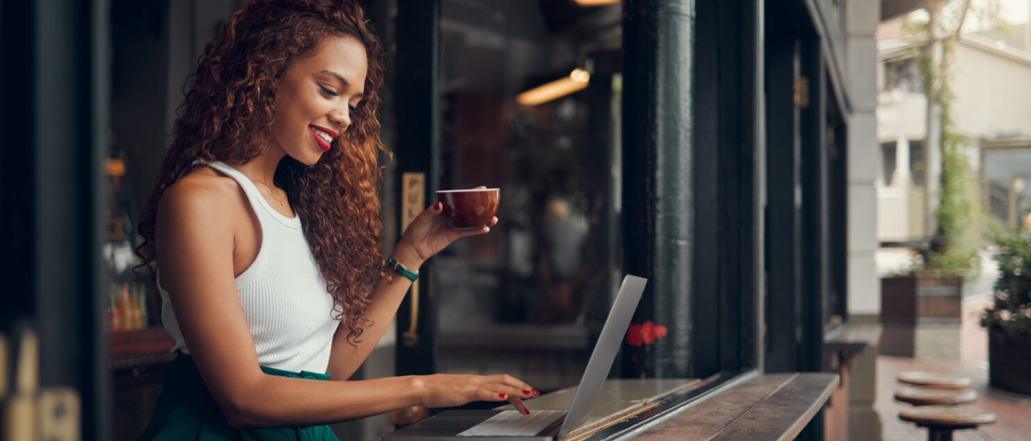 Remote work in cafe, laptop and blogger, woman with a coffee, working on content research for blog. Young, creative writer and freelance work, social network and internet search for ideas