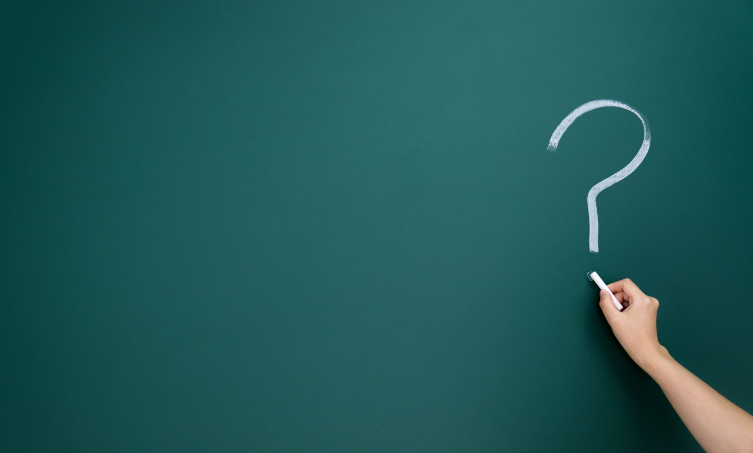 Question marks written on blackboard